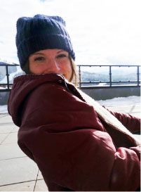 Morgan McCord peeking over her jacket color. Wearing beanie hat. Snow in background.
