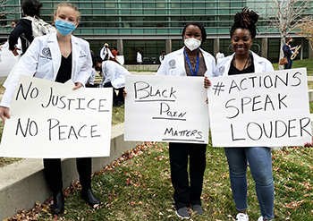 students holding signs on research quad