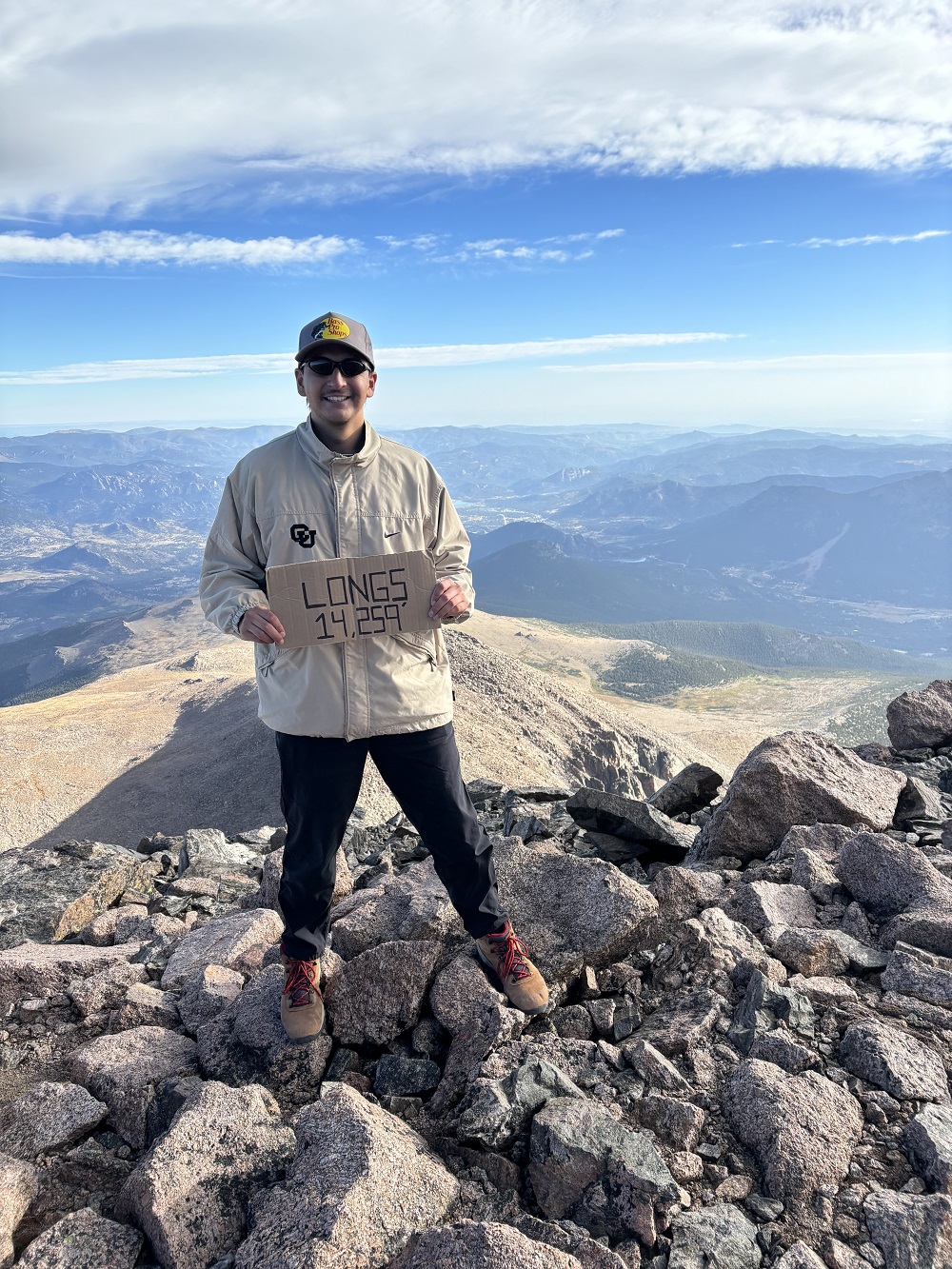 Gio Beltran standing at the top of Longs Peak.
